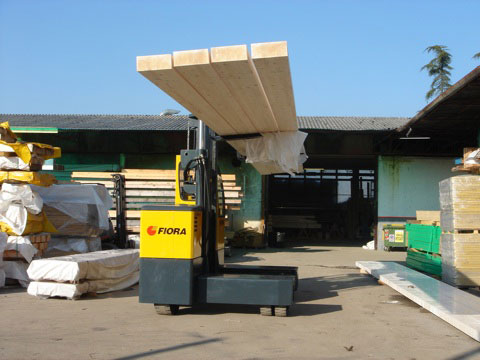 Orderly outdoor lumber and supply yard serviced with an outdoor electric sideloader 